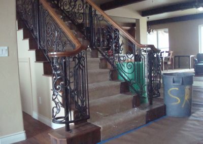 Indoor staircase railing with wood top cap and volutes